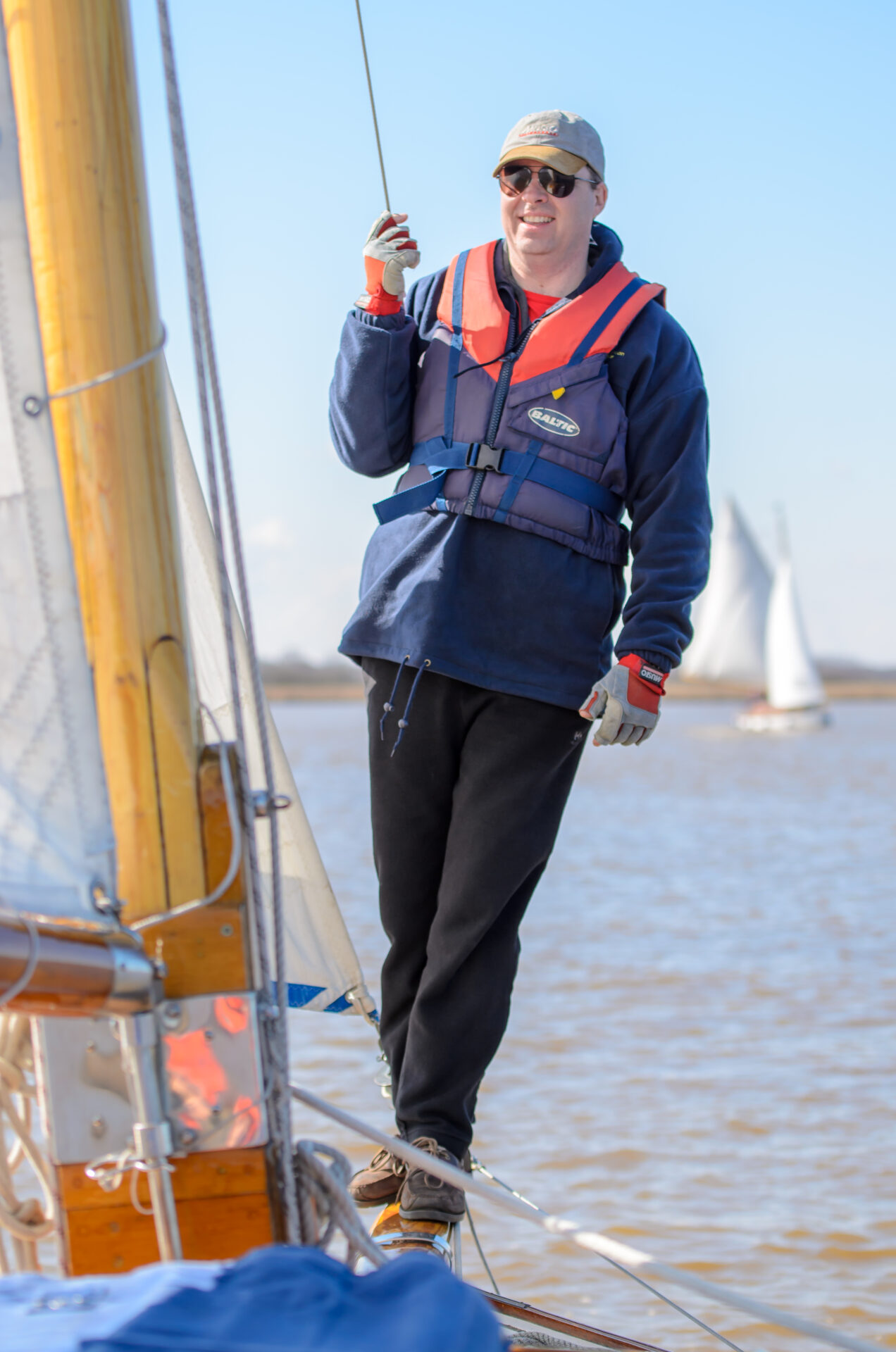 Andy holding on to the sail of a classic sailing yacht